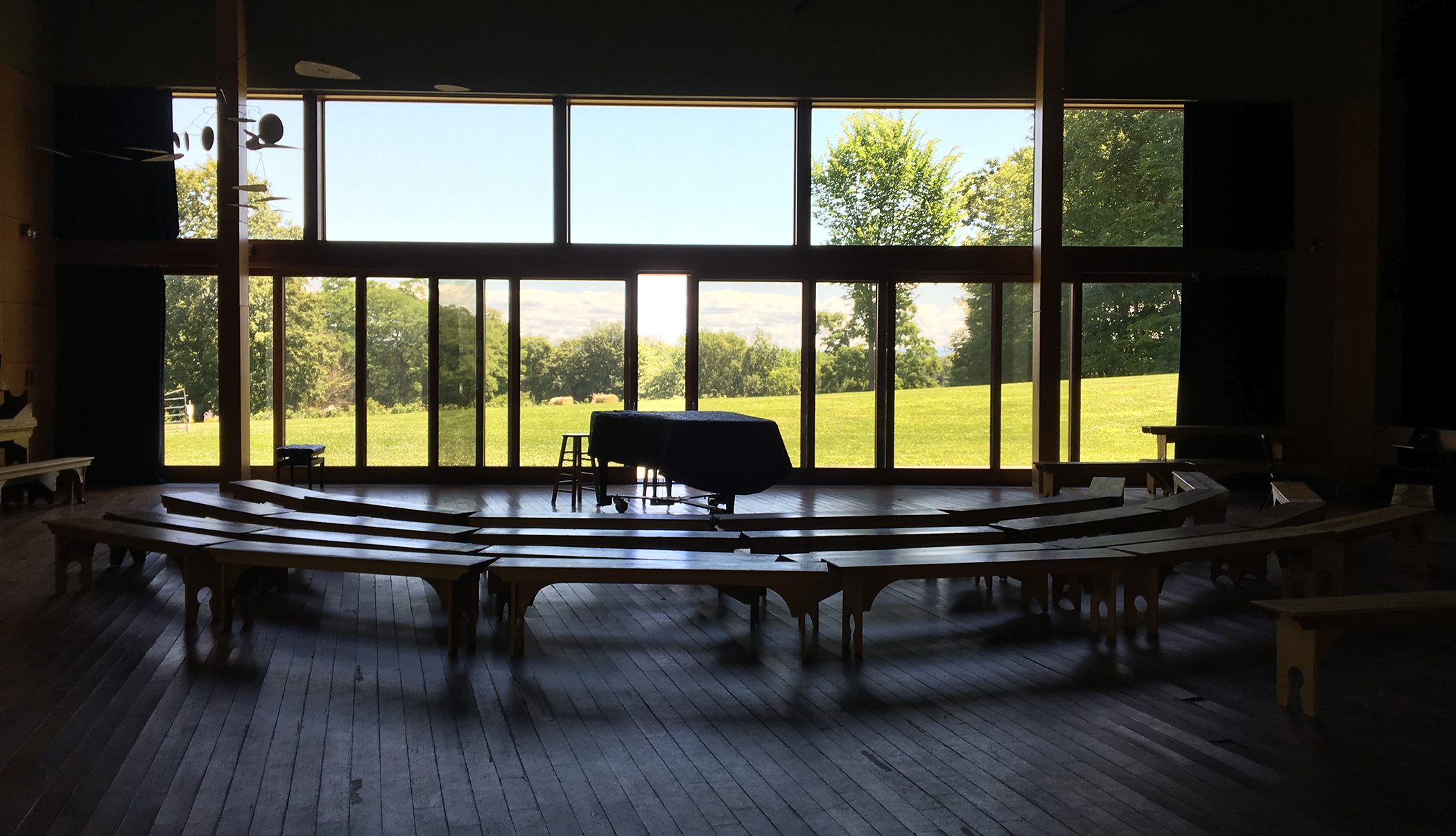 Piano in large room with tall windows