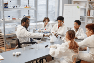 African American male science teacher in a wheelchair demonstrating lab experiments to students