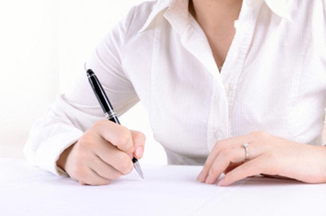 business woman's hands writing with pen