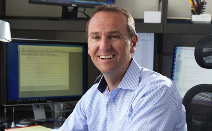 Scott Roy smiling at his desk