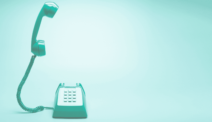 image of a teal landline phone with the phone receiver floating above the phone base