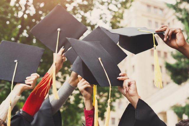 Group of graduates throwing their hats into the air