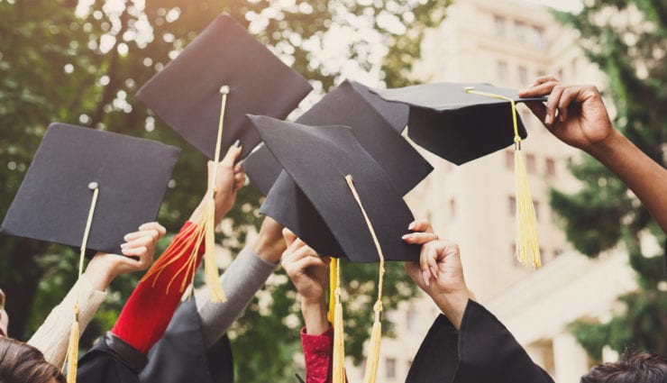 Group of graduates throwing their hats into the air