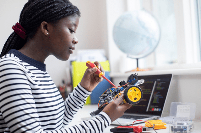 A Black female student works on a robotics project