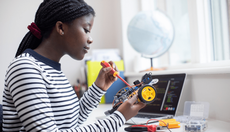 A Black female student works on a robotics project