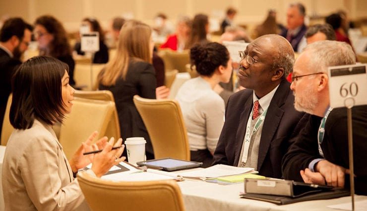 three people sitting at a table talking