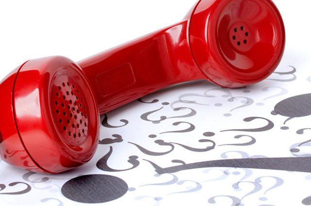 Red phone on floor covered in question marks