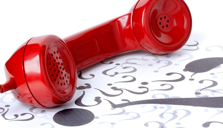 Red phone on floor covered in question marks