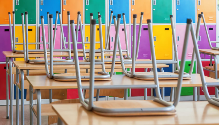 Chairs on top of desks in a closed classroom