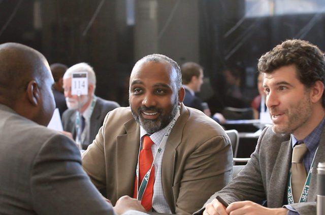 three men in suits conduct an interview