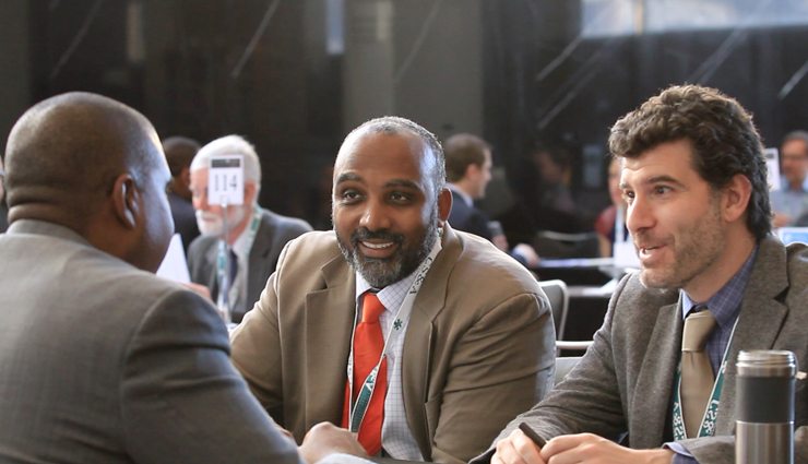 three men in suits conduct an interview