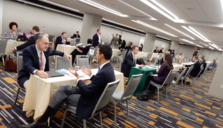 Businessmen and women interview in a large room full of tables