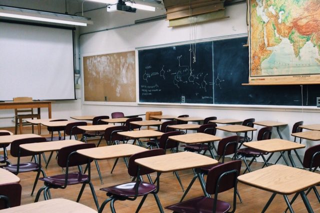 Rows of empty desks in a classroom