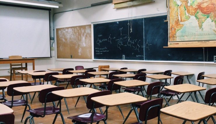 Rows of empty desks in a classroom