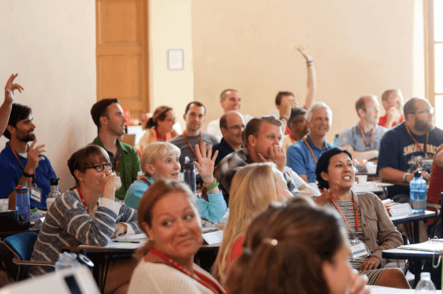 Group of teachers engaged in professional development while seated at desks in a classroom