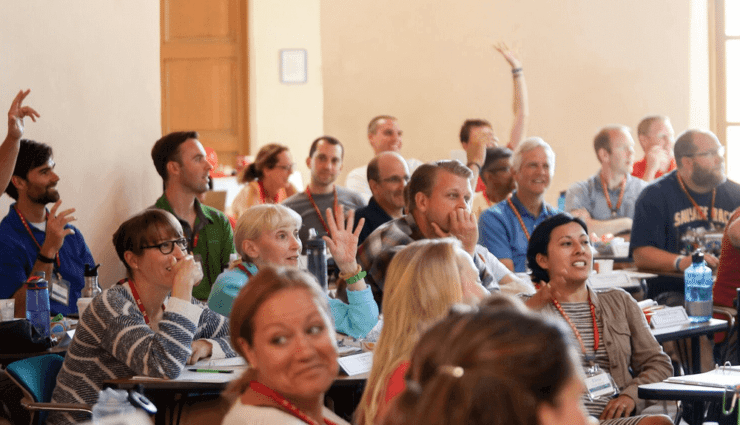 Group of teachers engaged in professional development while seated at desks in a classroom