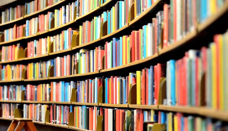 Rows of full stacks of colorful books in library