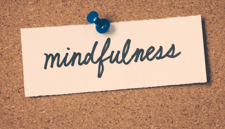 Mindfulness written on a piece of paper pinned to a corkboard