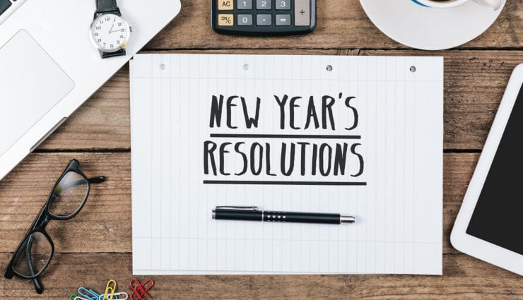 note with “new years resolution” text, Office desk with electronic devices, computer and paper