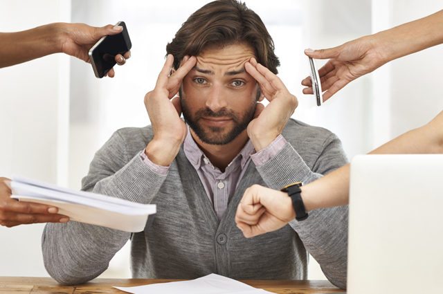 man is under stress as he is handed lots to do