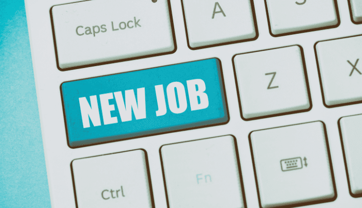 Close up of a computer keyboard and one of the long buttons has been replaced by a teal button with the words "new job"