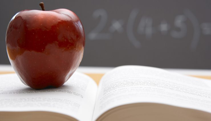 Apple on book with chalkboard behind