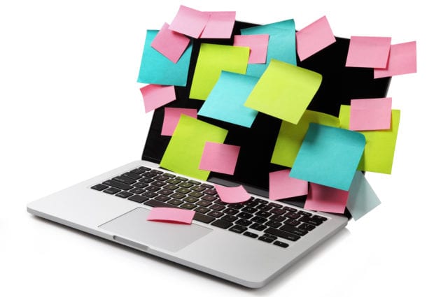 Image of laptop full of colorful sticky notes reminders on screen