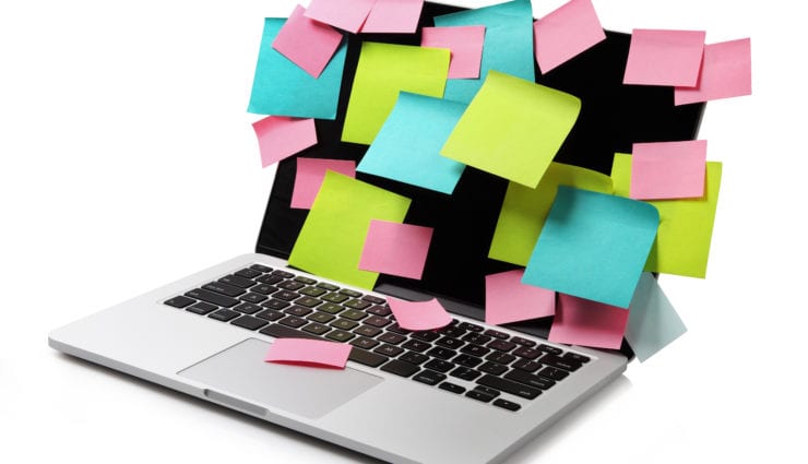 Image of laptop full of colorful sticky notes reminders on screen