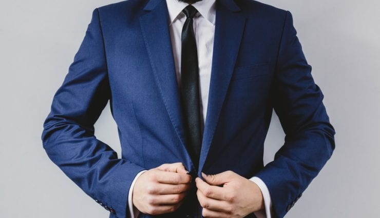 business man puts on his blue suit jacket