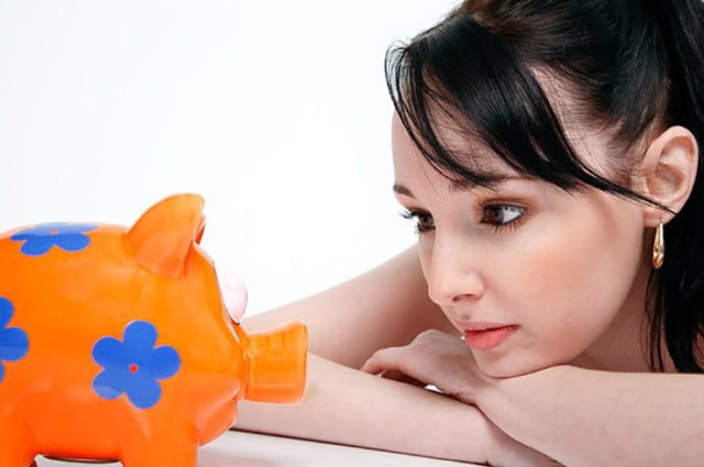 woman stares at orange and blue flowered piggy bank