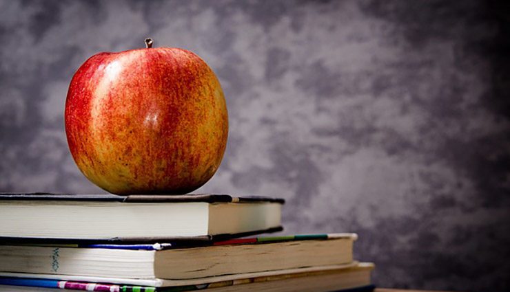 stack of textbooks with colorful red-yellow apple