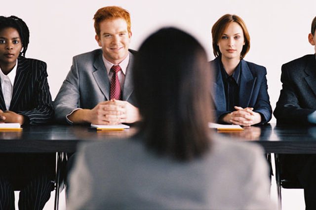 Panel of businesspeople conduct interview