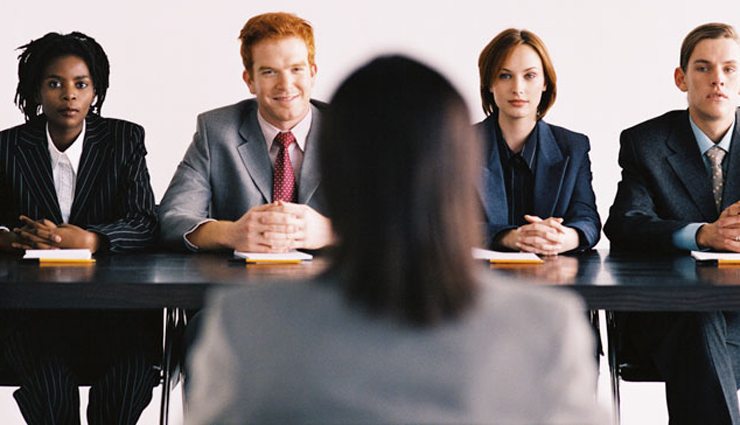 Panel of businesspeople conduct interview