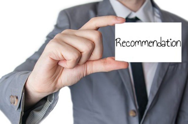 Man in suit holds index card reading 