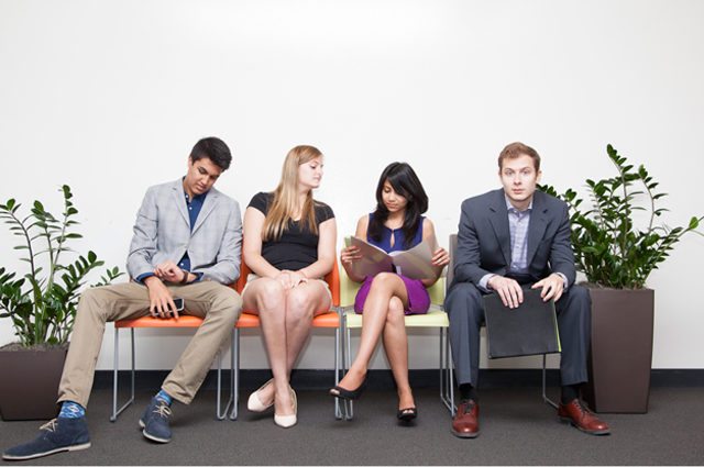 four college candidates wait for an interview in colorful chairs