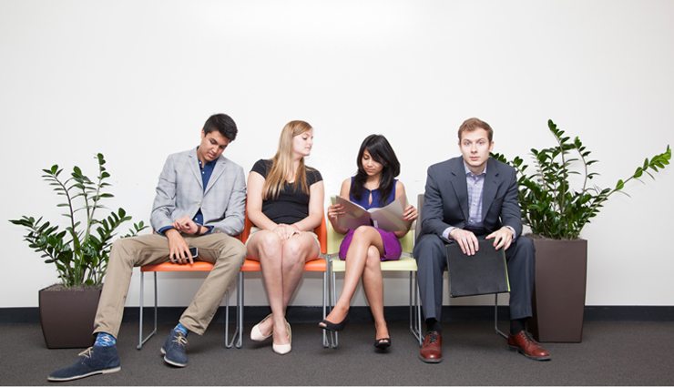four college candidates wait for an interview in colorful chairs