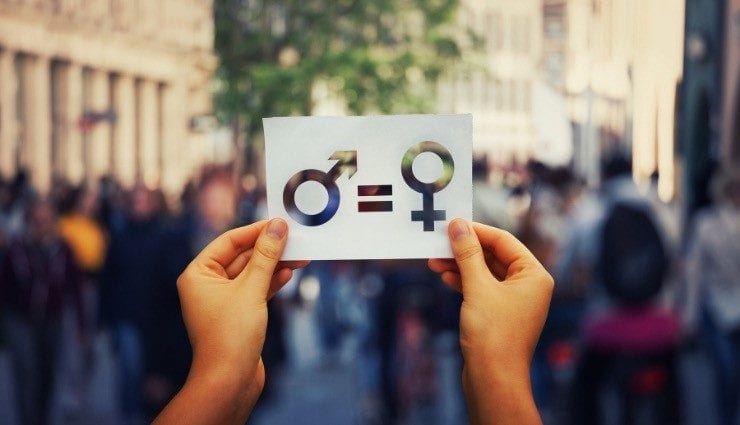 Two hands holding a piece of paper with the symbols for male and female cut out