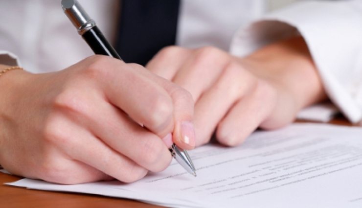 Zoomed in on woman's hand completing a form