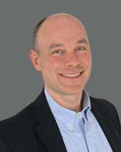 Smiling man in a suit with a gray background