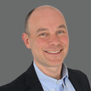 Smiling man in a suit with a gray background