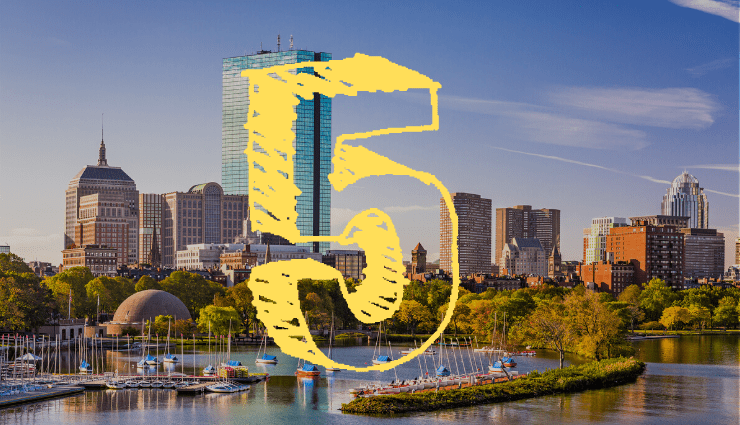 Yellow number 5 over a city skyline with blue sky and greenery in the foreground.
