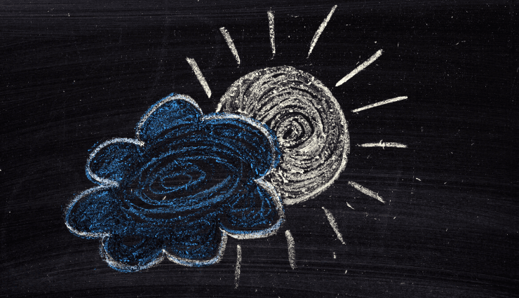 Chalk drawing of a swirling sun partially obscured by a blue cloud on a blackboard background.