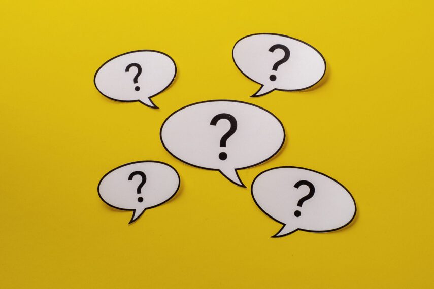 Five white speech bubbles with question marks on a yellow background