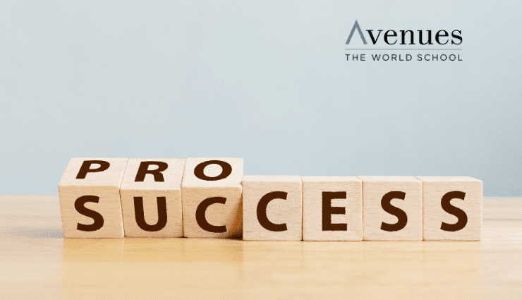 Scrabble tiles showing the word "SUCCESS" with two tiles missing against a light blue background on a wooden surface.