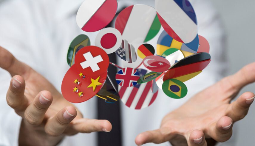 Flags of various countries floating above a person's open hands, symbolizing global communication and diversity.