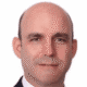 Bald man in a suit with a neutral expression on a white background.