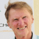 Man smiling in front of a banner.