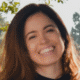 Smiling person standing outdoors with trees in the background
