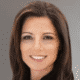 Smiling person with dark hair against a neutral background