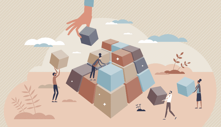 People stacking large cubes to form a pyramid, illustrating teamwork and collaboration in a desert-like landscape.